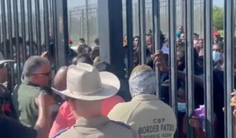 Video Shows Massive Groups Of Migrants Attempting To Force Their Way Through Border Gate